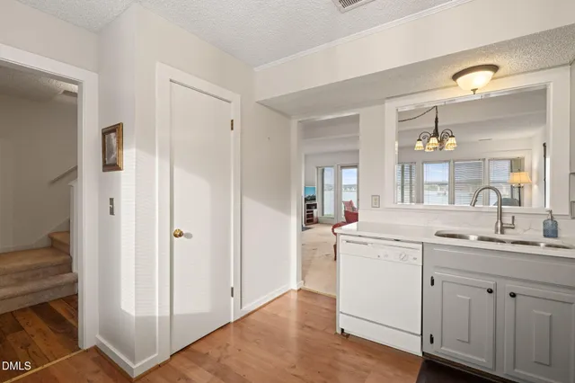 a kitchen with white cabinets and sink