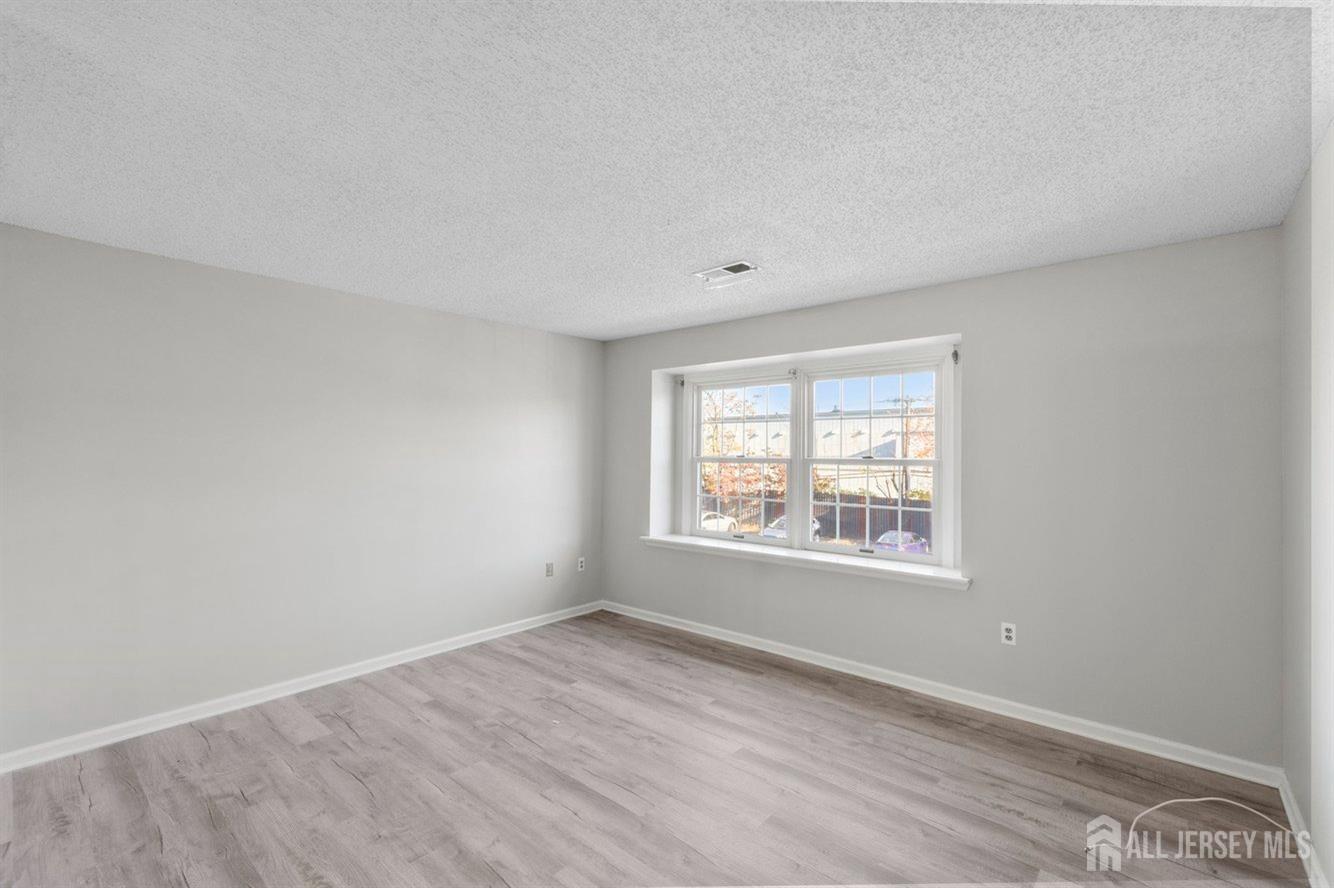 724 Edpas Road New Brunswick, NJ 08901 - Photo 16 of 24 an empty room with wooden floor and windows