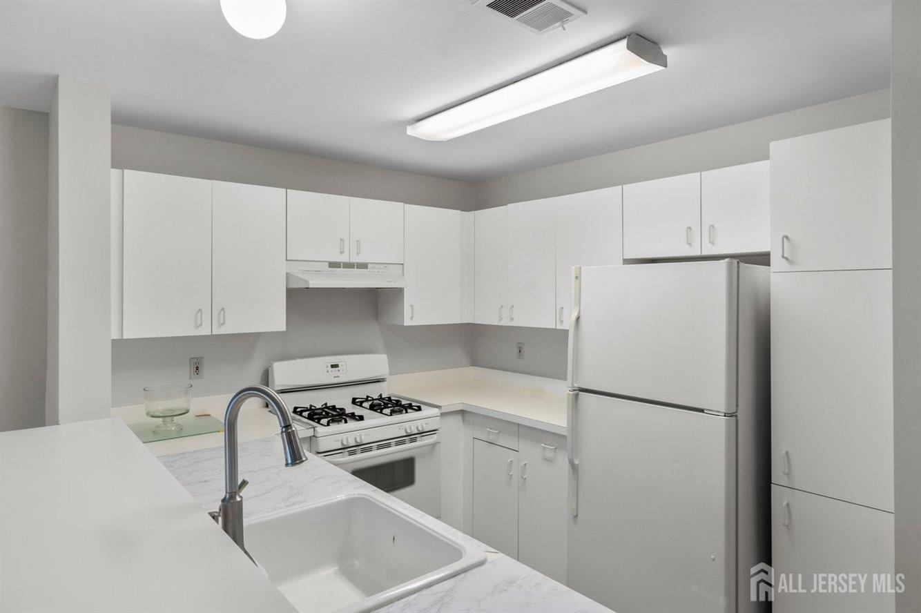 724 Edpas Road New Brunswick, NJ 08901 - Photo 6 of 24 a kitchen with white cabinets and white appliances
