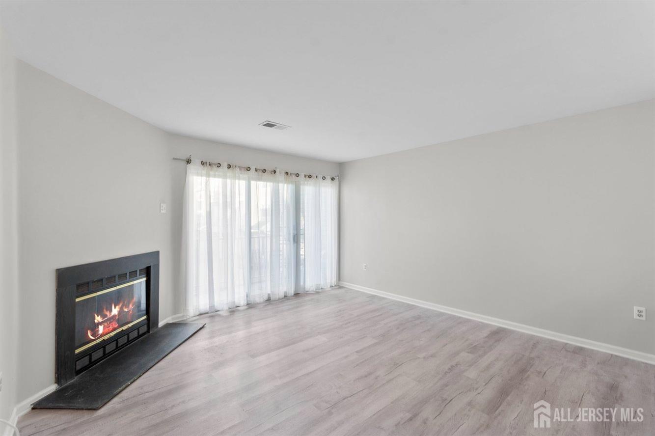 724 Edpas Road New Brunswick, NJ 08901 - Photo 9 of 24 a view of an empty room with a fireplace and a window