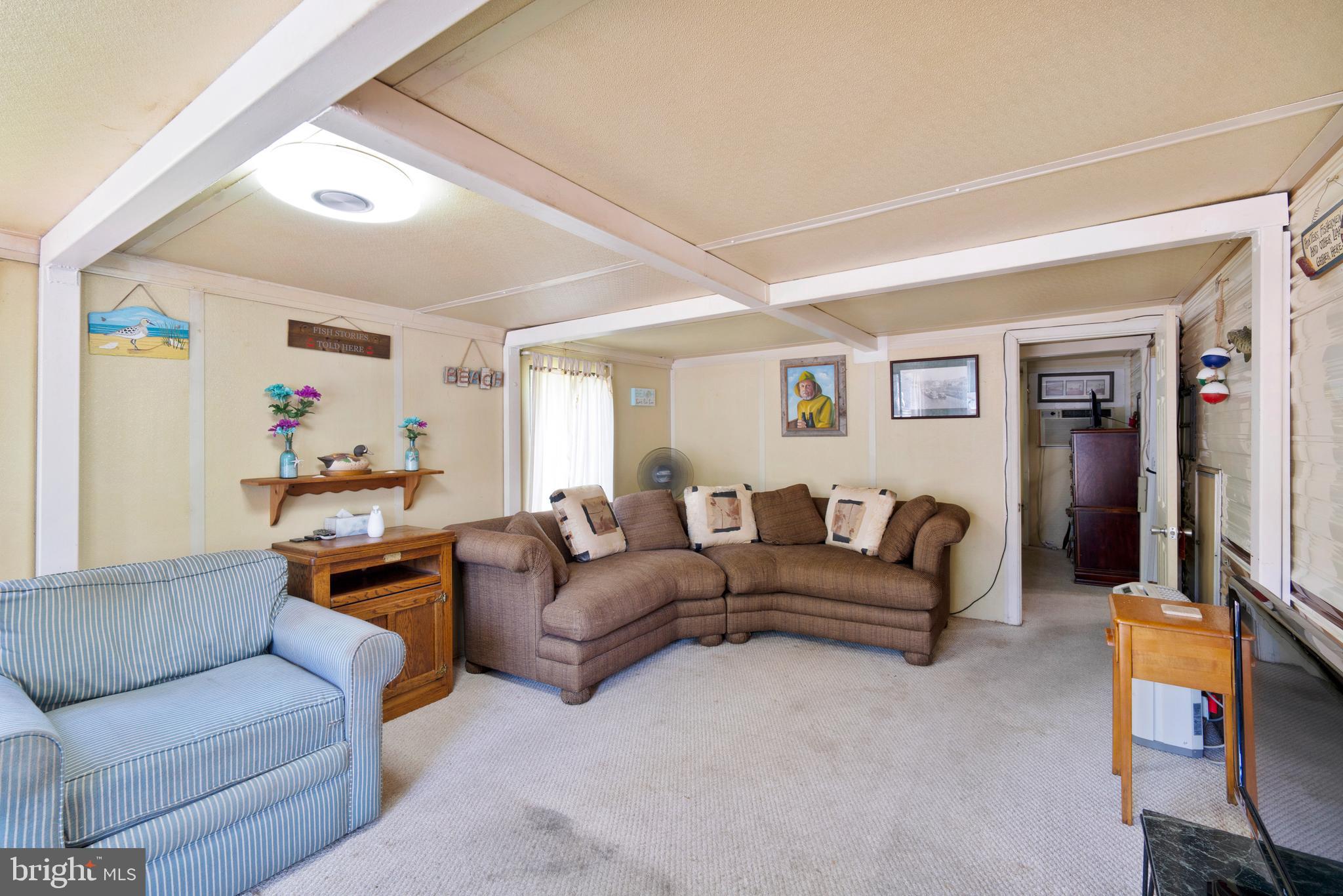111 Beach Harbor Road, Unit 11F Grasonville, MD 21638 - Photo 4 of 13 a living room with furniture and a flat screen tv