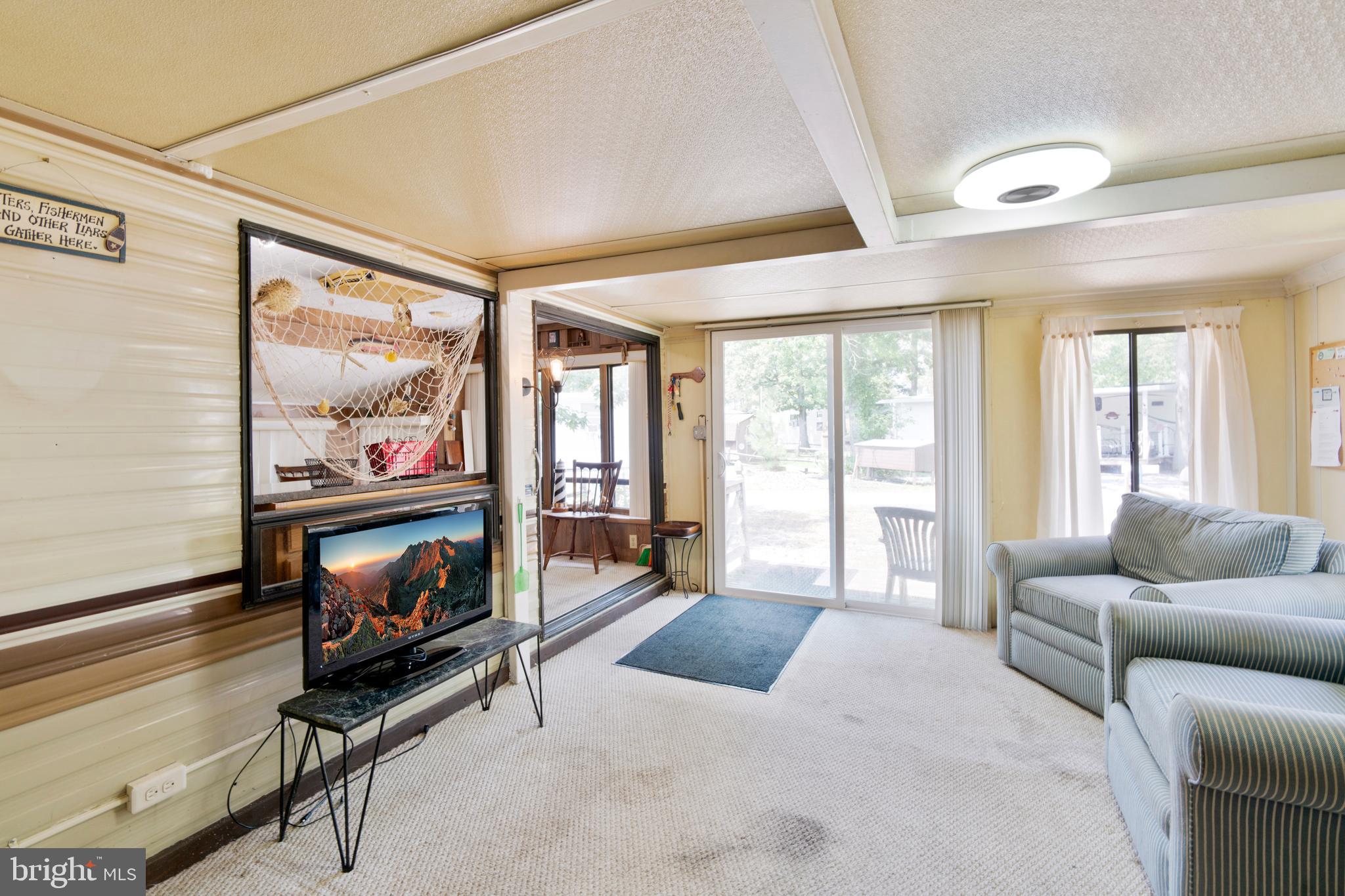 111 Beach Harbor Road, Unit 11F Grasonville, MD 21638 - Photo 5 of 13 a bedroom with furniture and a flat screen tv