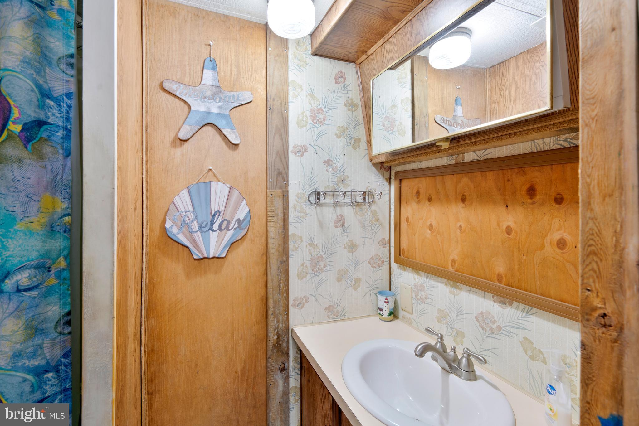 111 Beach Harbor Road, Unit 11F Grasonville, MD 21638 - Photo 8 of 13 a bathroom with a sink and a mirror