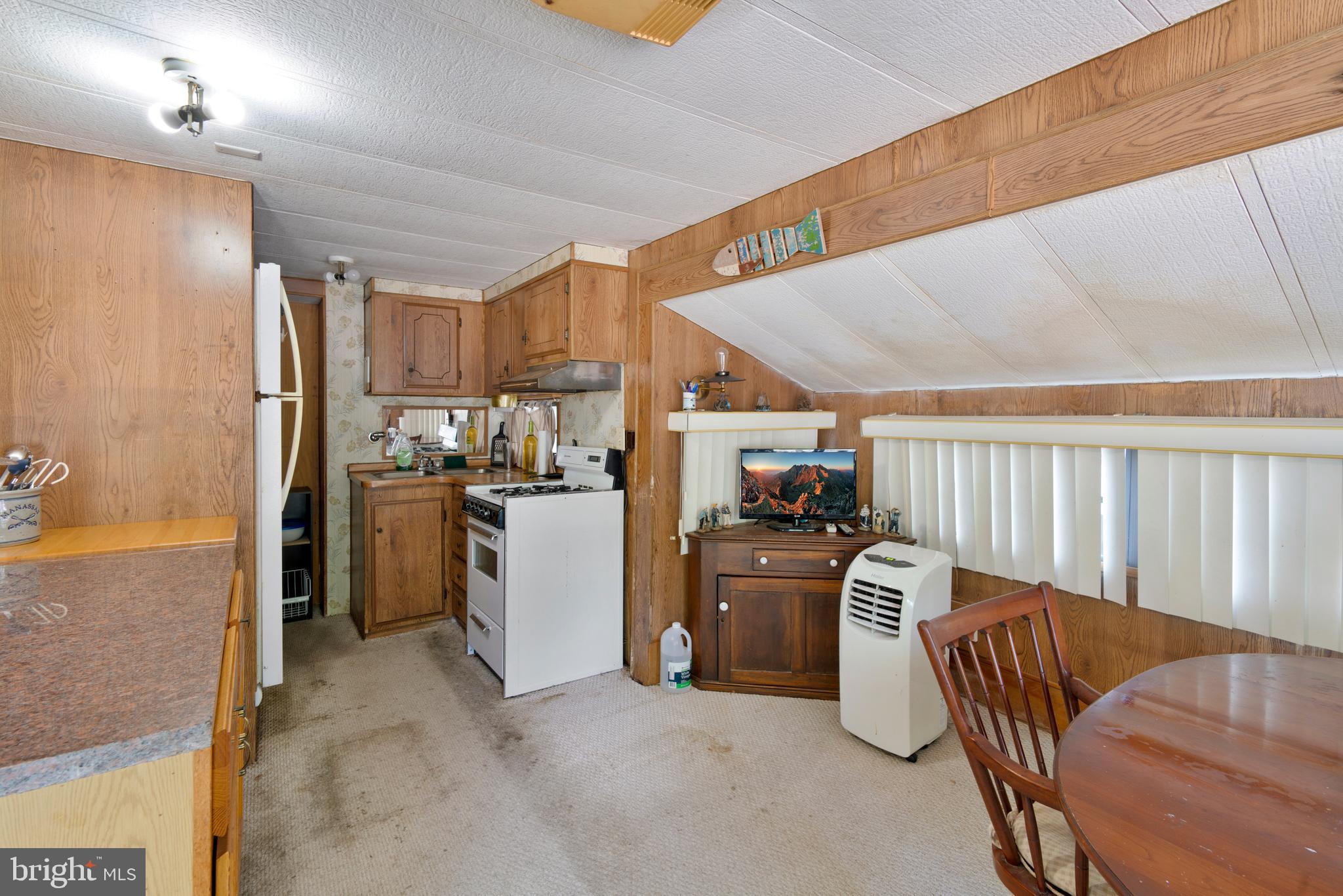 111 Beach Harbor Road, Unit 11F Grasonville, MD 21638 - Photo 10 of 13 a kitchen with refrigerator and cabinets