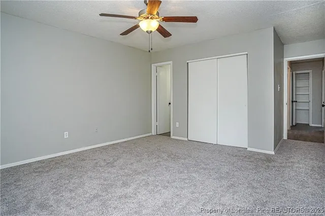 a bathroom with a granite countertop toilet sink and mirror