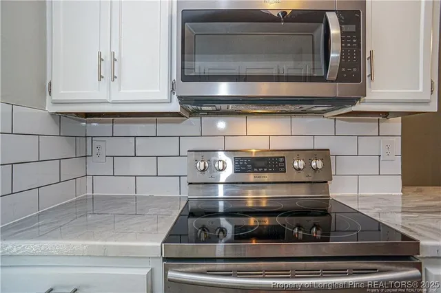 a stove top oven sitting inside of a kitchen and granite counter