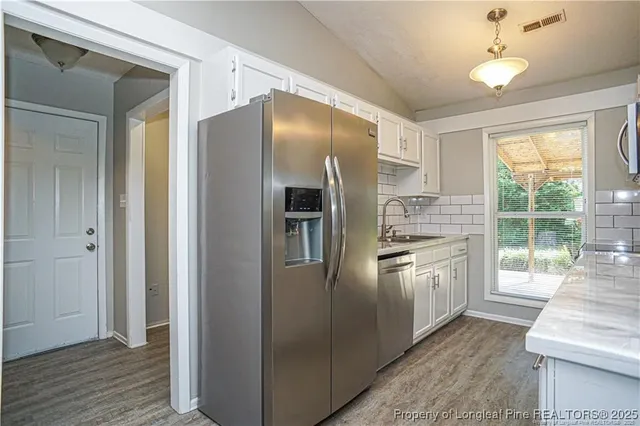 a kitchen with stainless steel appliances granite countertop a refrigerator and a sink