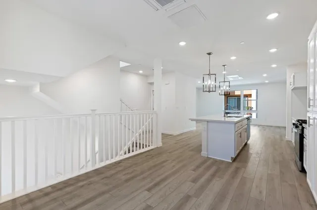 a kitchen with kitchen island granite countertop a sink cabinets and wooden floor
