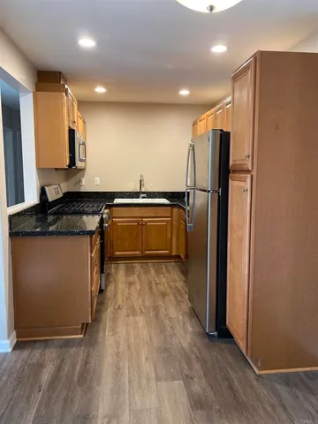 a kitchen with granite countertop a refrigerator and a sink