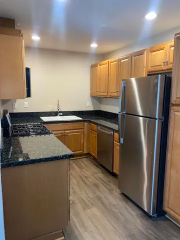 a kitchen with stainless steel appliances granite countertop a sink a stove microwave and cabinets