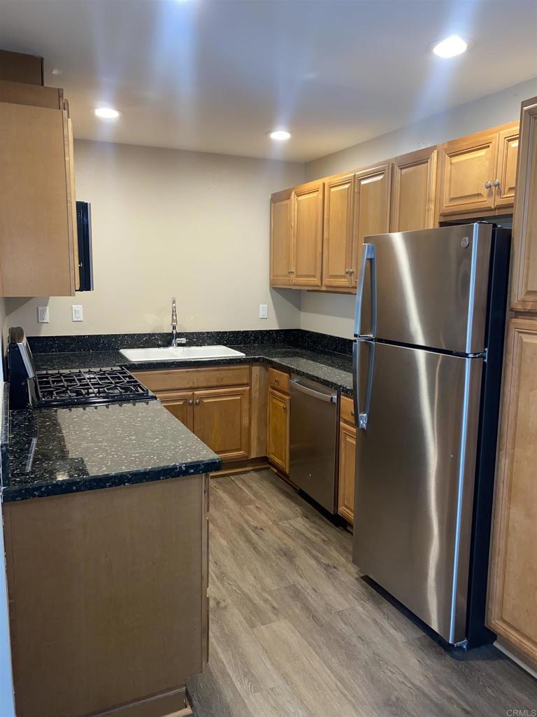 2088 Montgomery Avenue, Unit M Cardiff-by-the-Sea, CA 92007 - Photo 20 of 43 a kitchen with granite countertop stainless steel appliances a refrigerator a sink a stove a microwave and cabinets