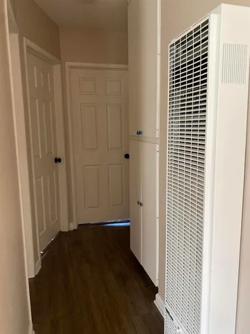 an empty room with a fan & a window