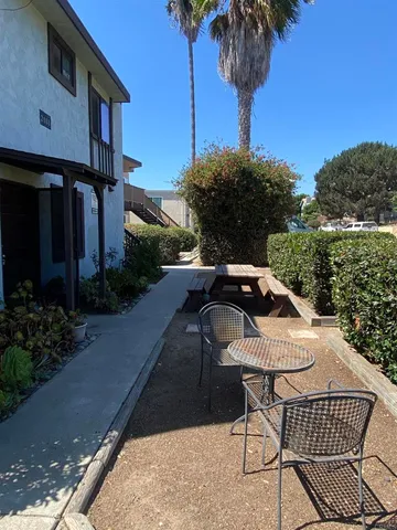 a view of a patio with table and chairs potted plants