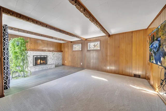 a view of an empty room with a fireplace and a window