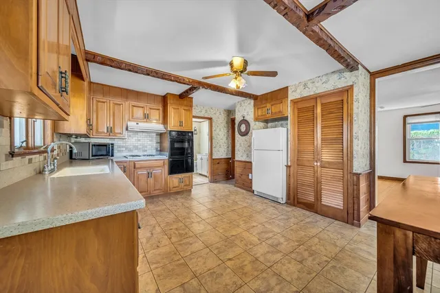 a kitchen with stainless steel appliances granite countertop a sink and a refrigerator