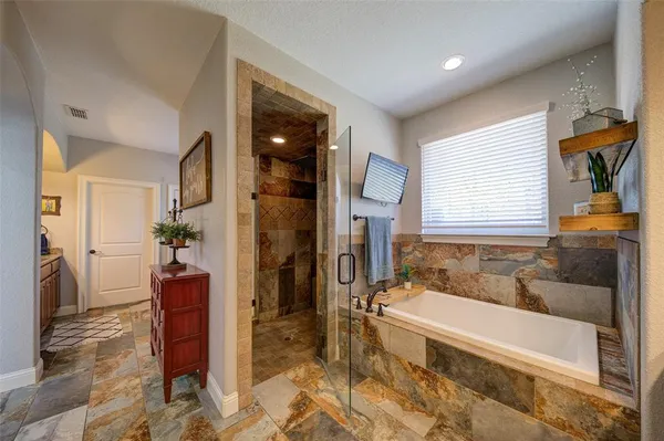 a spacious bathroom with bathtub and shower