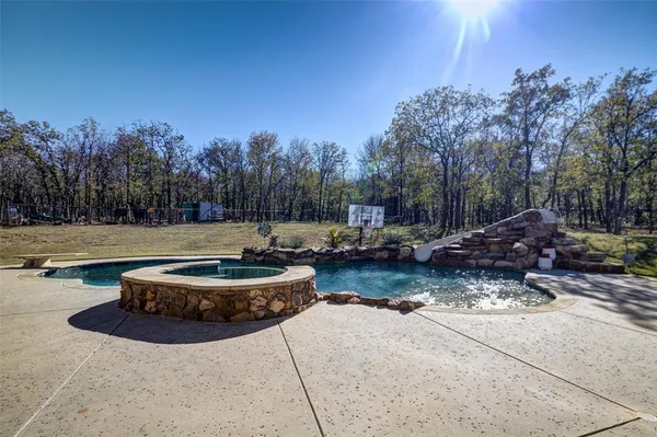 a view of a backyard with trees and cars