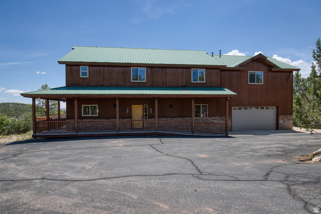 755 South Zion Ridge Drive Orderville, UT 84758 - Photo 11 of 84 Chalet / cabin featuring an attached garage, a porch, a metal roof, and driveway