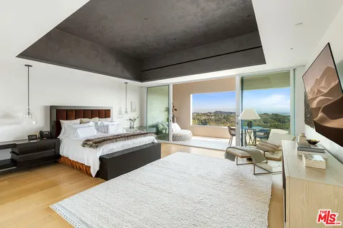 a bedroom with two beds and a large window