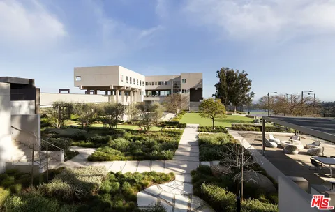 a view of a dining room with furniture one side kitchen view and wooden floor