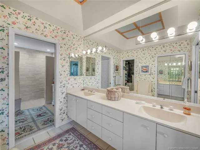 a bathroom with a double vanity sink mirror and shower