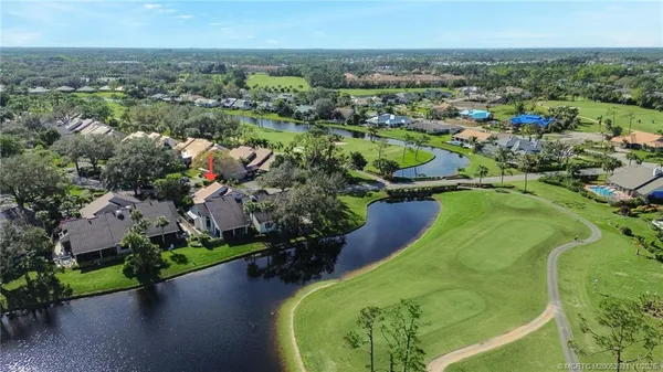 an aerial view of a house with a garden and lake view