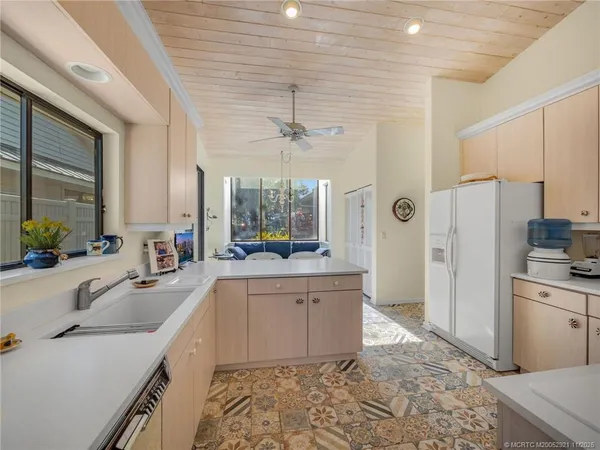 a large kitchen with a sink and refrigerator