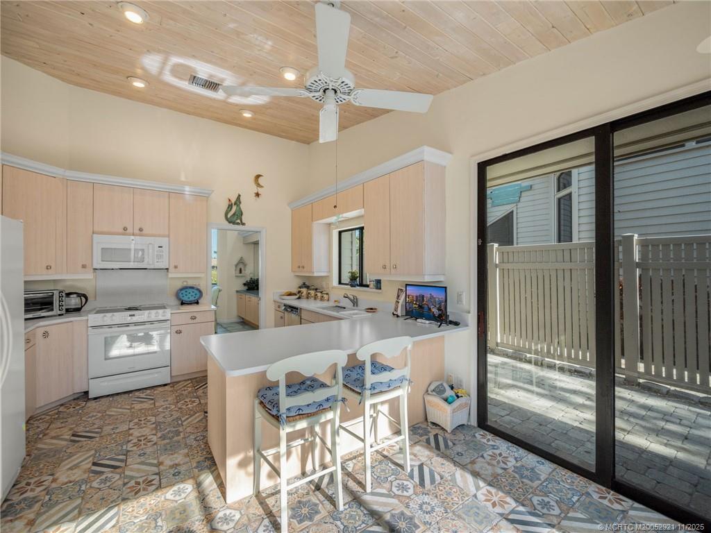 5011 Southeast Brandywine Way Stuart, FL 34997 - Photo 8 of 19 a kitchen with microwave a stove and refrigerator