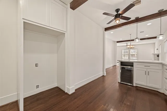 a view of an empty room with wooden floor fireplace and a window