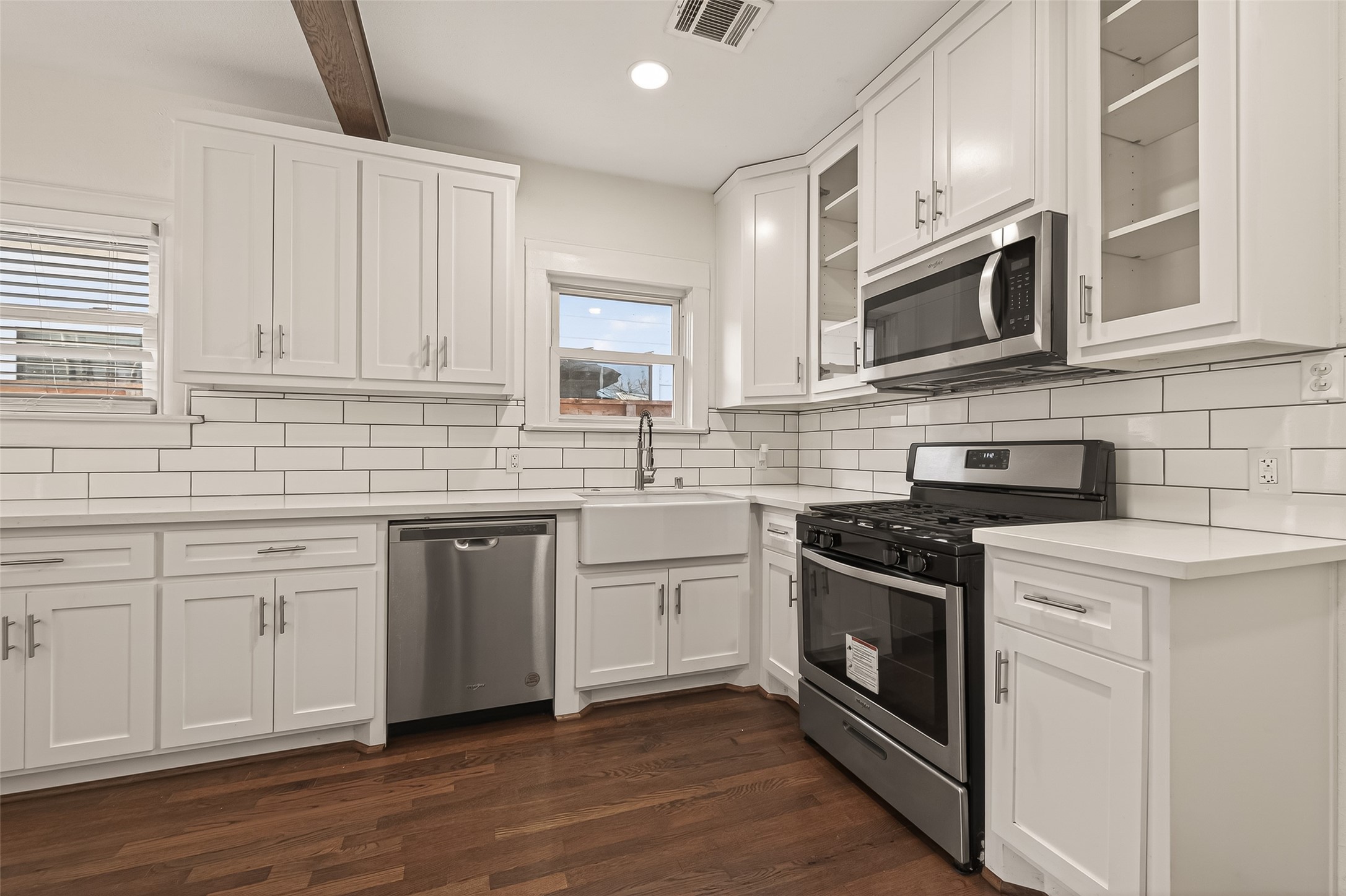 2417 Ruth Street Houston, TX 77004 - Photo 9 of 33 a kitchen with stainless steel appliances granite countertop white cabinets a sink a stove a microwave and cabinetry