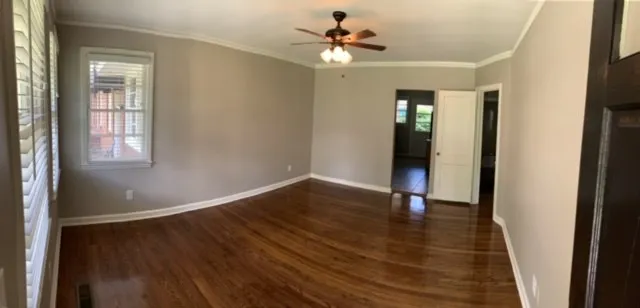 a view of an empty room with wooden floor