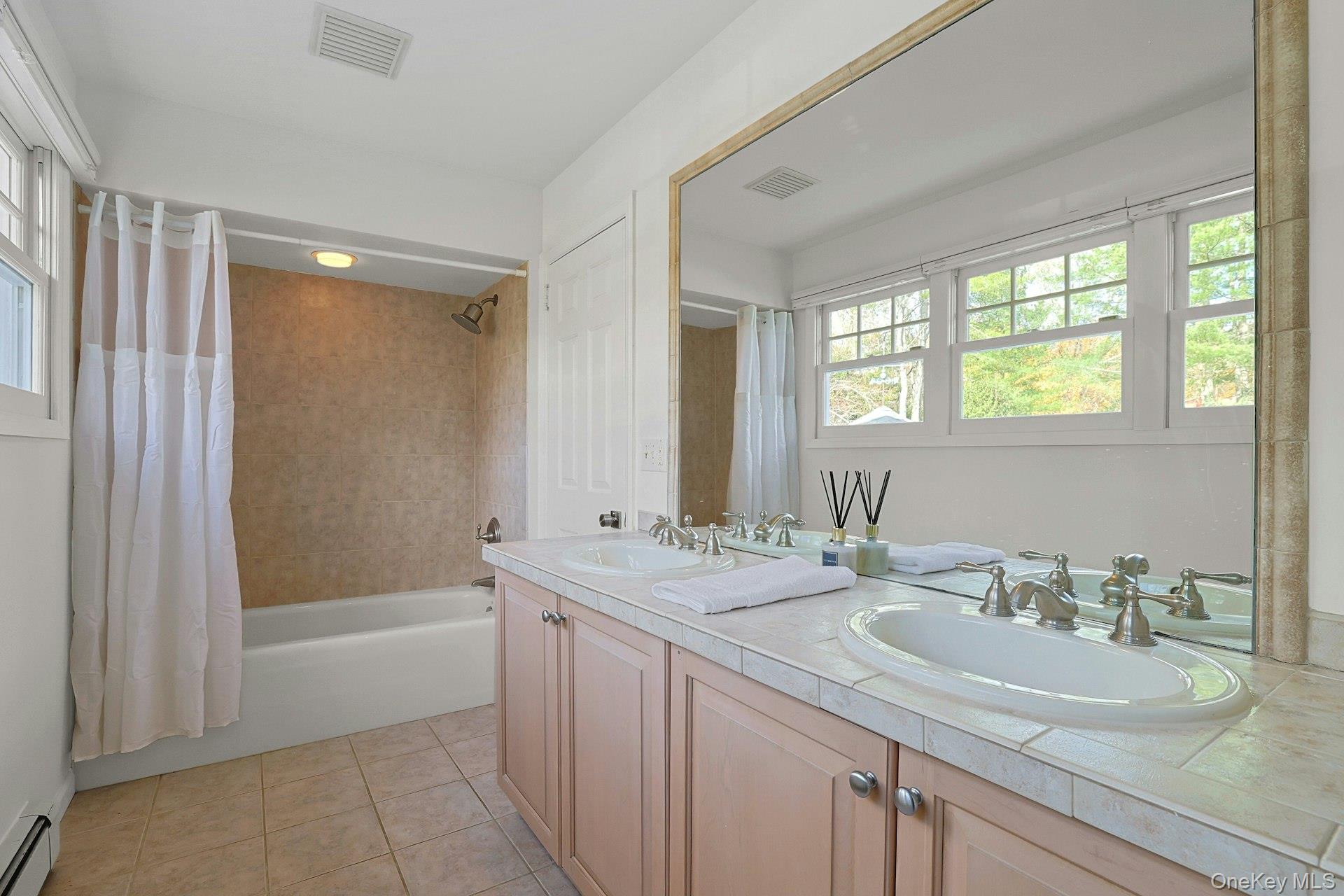 8 Creemer Road Armonk, NY 10504 - Photo 23 of 38 a bathroom with a granite countertop sink a mirror a bathtub and next to a window