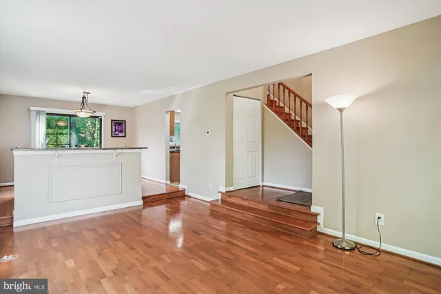 a view of a livingroom with wooden floor and stairs