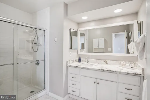 a bathroom with a granite countertop sink a mirror a shower and a mirror
