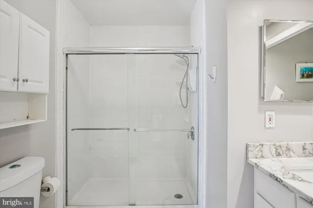 a bathroom with a granite countertop shower and a sink