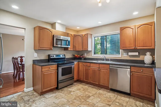 a kitchen with stainless steel appliances granite countertop a stove sink and microwave