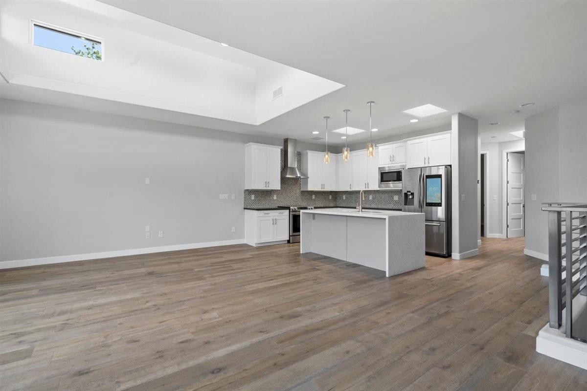 1214 West 5th Street, Unit 2 Tempe, AZ 85281 - Photo 5 of 26 a large kitchen with kitchen island a stove a refrigerator a sink dishwasher and a oven with wooden floor