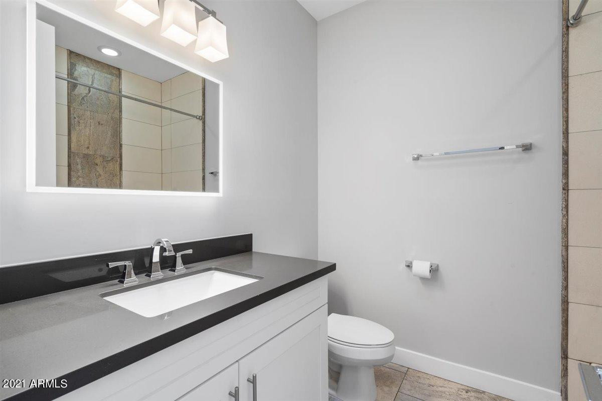 1214 West 5th Street, Unit 2 Tempe, AZ 85281 - Photo 8 of 26 a bathroom with a granite countertop sink a toilet and a mirror