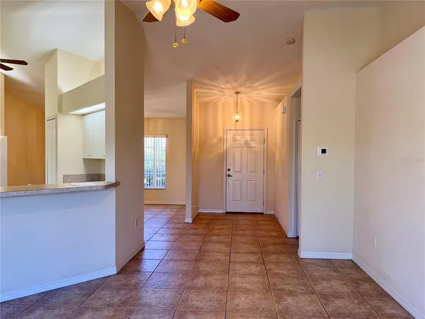 a view of a hallway with wooden floor and a chandelier