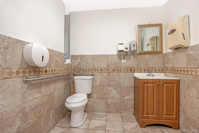 a bathroom with a granite countertop toilet sink mirror and vanity