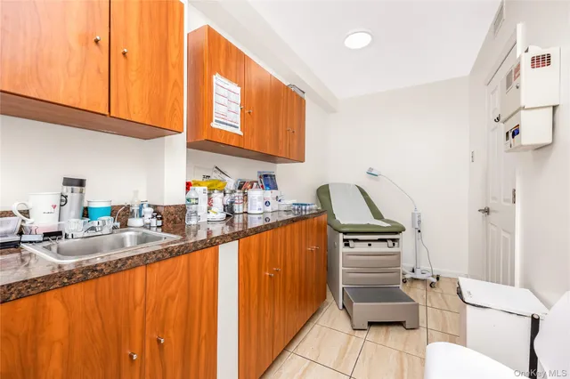 a kitchen with granite countertop a stove a sink and a refrigerator