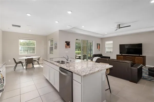 a white kitchen with a stove a sink and a refrigerator