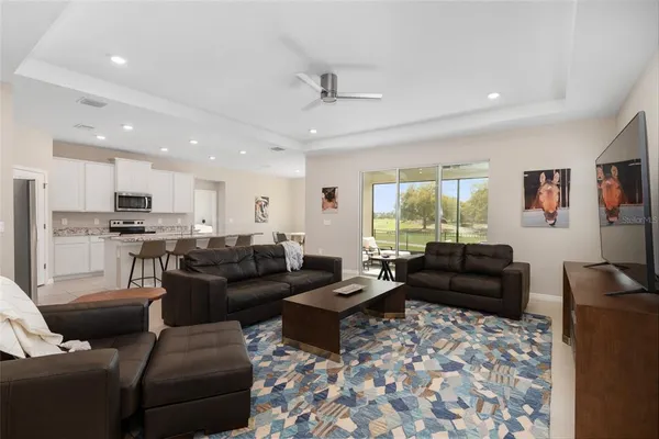 a kitchen with stainless steel appliances granite countertop a table chairs sink refrigerator and microwave