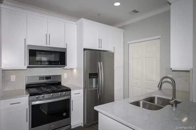 a kitchen with stainless steel appliances a stove a microwave and a refrigerator