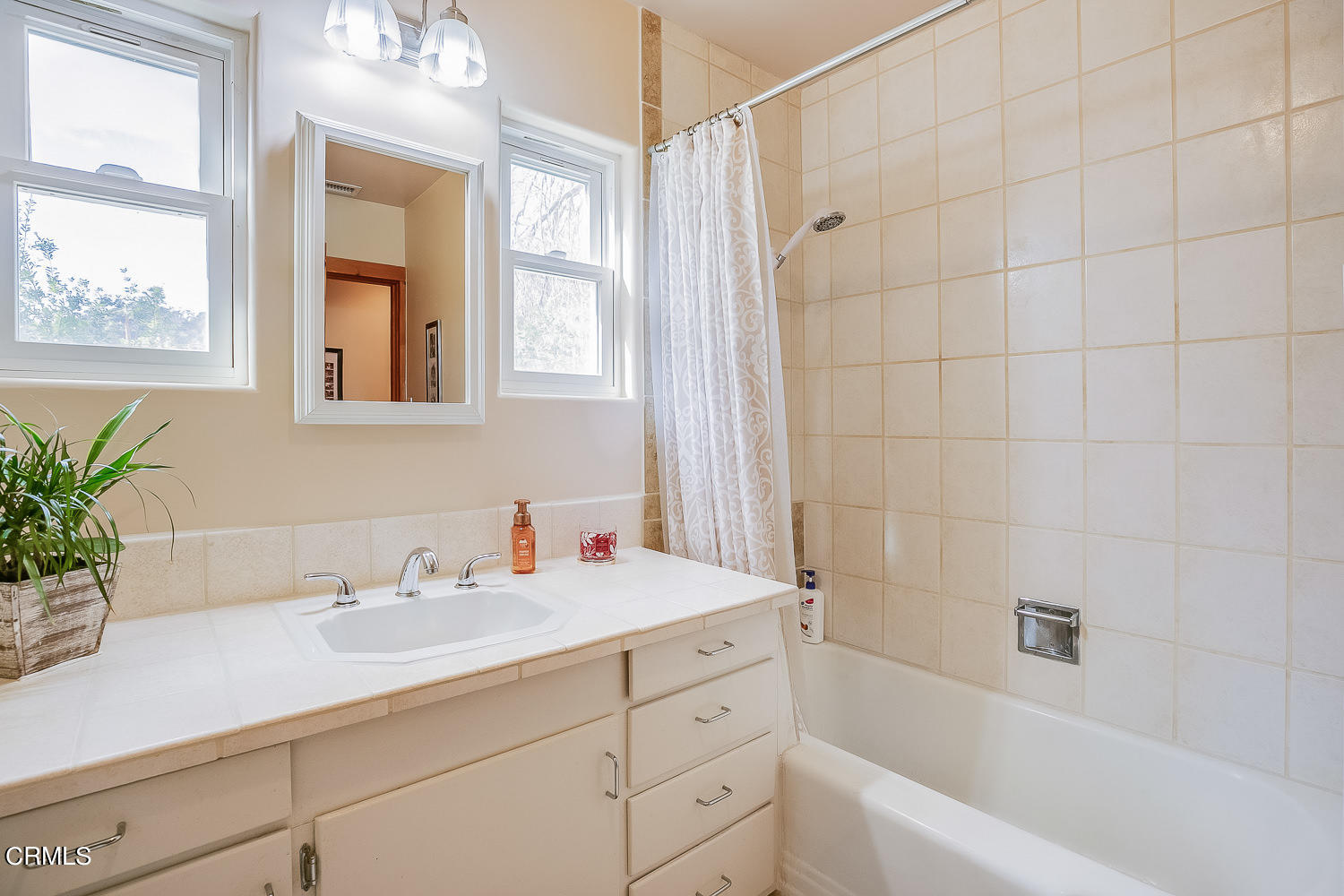 9972 Creek Road Oak View, CA 93022 - Photo 18 of 50 a bathroom with a sink a mirror a bathtub and next to a window
