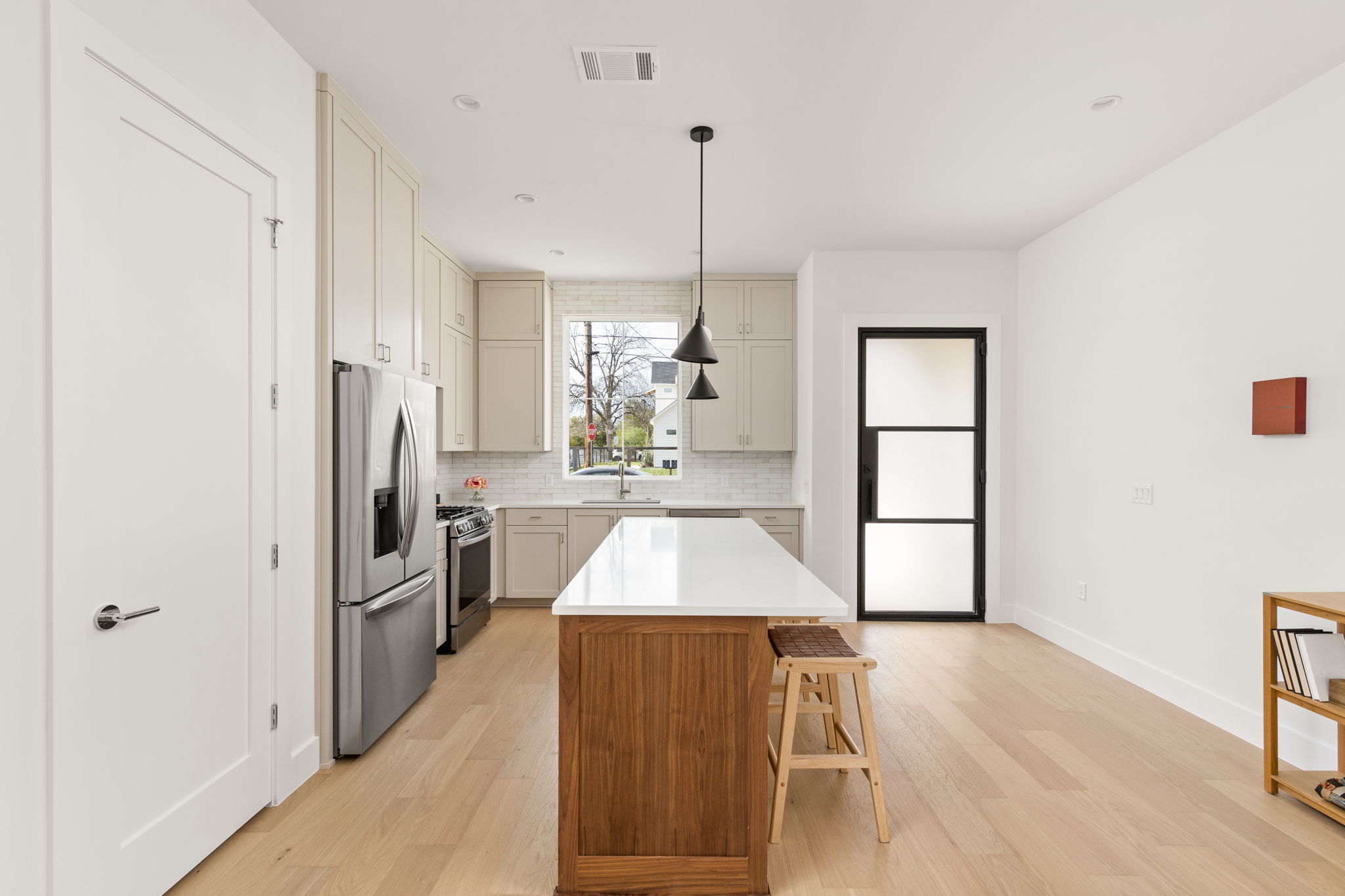 2910 East 4th Street Austin, TX 78702 - Photo 6 of 39 a kitchen with stainless steel appliances kitchen island granite countertop a refrigerator and a sink