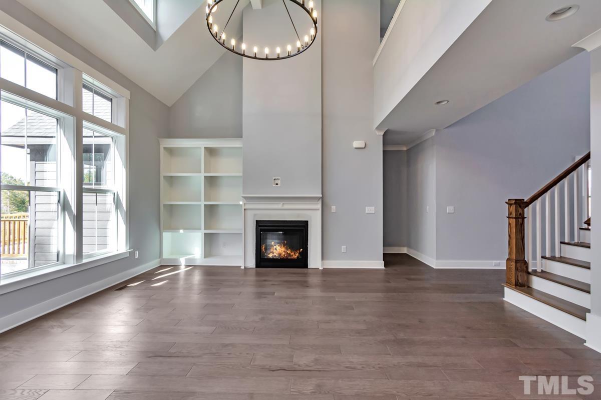 6409 Camellia Creek Drive Raleigh, NC 27603 - Photo 12 of 30 a view of an empty room with wooden floor fireplace and a window