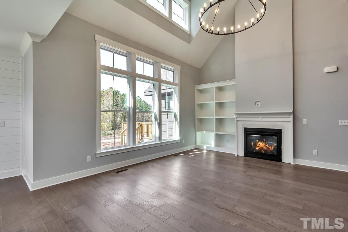 6409 Camellia Creek Drive Raleigh, NC 27603 - Photo 20 of 30 an empty room with wooden floor fireplace and windows