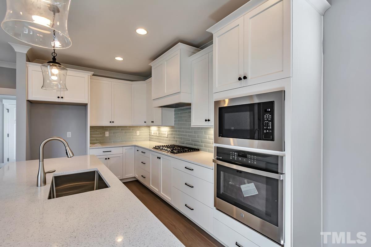 6409 Camellia Creek Drive Raleigh, NC 27603 - Photo 22 of 30 a kitchen with granite countertop white cabinets and white appliances