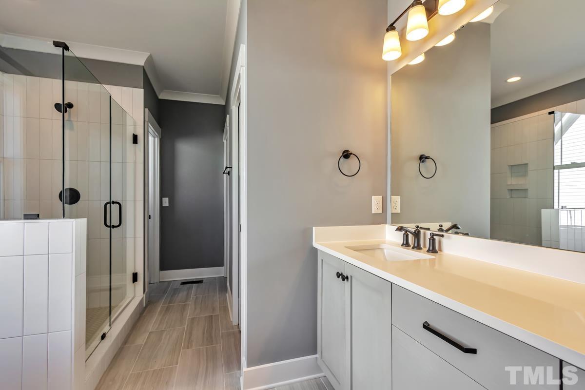 6409 Camellia Creek Drive Raleigh, NC 27603 - Photo 25 of 30 a bathroom with a sink a mirror a vanity and shower
